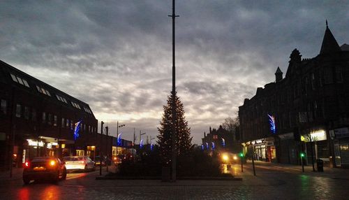 Cars on road in city against sky