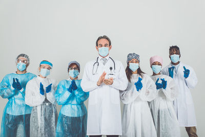 Doctors wearing mask standing against white background