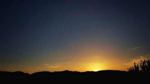 Scenic view of silhouette mountains against sky at sunset