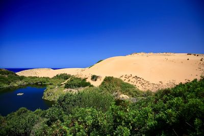 Scenic view of land against clear blue sky