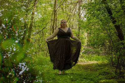 Portrait of woman standing in forest