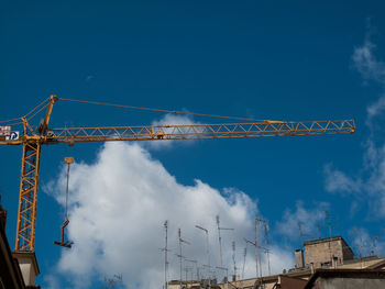 Low angle view of crane against sky