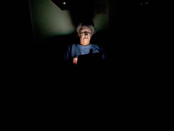 Full length of teenage girl in dark room