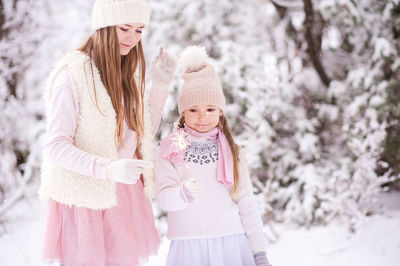 Sisters holding sparklers during winter