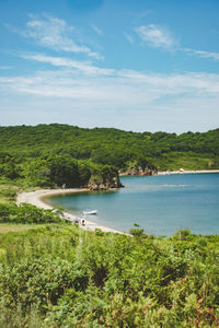 Summer azure clear sea panorama. shallow transparent sea with reefs, rocks and green hills 