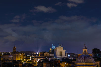 Illuminated cityscape against sky at night