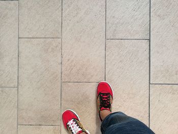 Low section of man standing on tiled floor