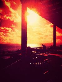 Sun shining through clouds over sea