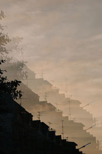 Low angle view of silhouette buildings against sky