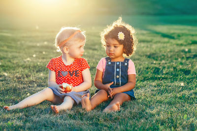 Cute girl sitting on grass at field