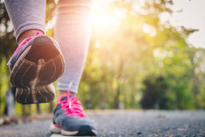 Low section of woman jogging on road