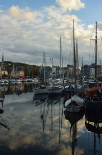 Sailboats moored at harbor