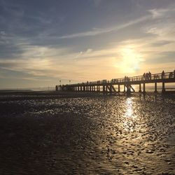 Pier on sea at sunset