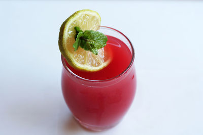 Close-up of drink on table against white background