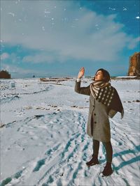 Woman standing on snow covered land