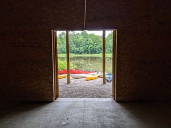 Opening of building looking upon boats next to small lake