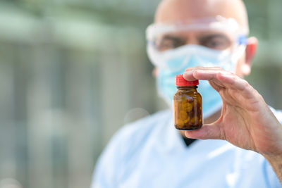 Close-up portrait of man holding bottle