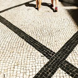 Low section of people walking on zebra crossing