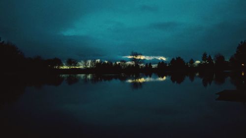 Scenic view of calm lake against cloudy sky