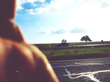 Close-up of man on field against sky