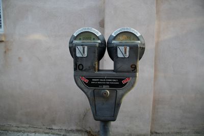 Close-up of telephone pole against wall