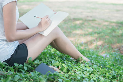 Midsection of woman using mobile phone in field