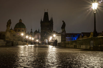 Illuminated buildings against sky at night