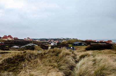 Houses on field against sky