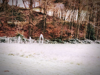 Man walking on snow covered field