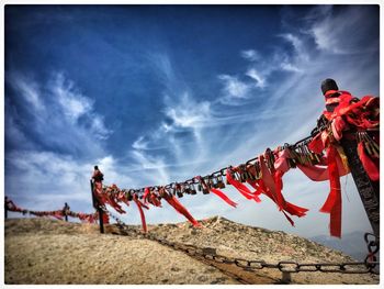 Locks and red ribbons on chain at mount hua against sky