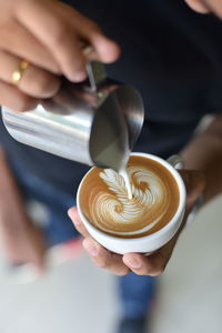 Close-up of hand holding coffee cup