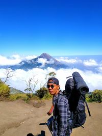 Portrait of man against mountains against blue sky