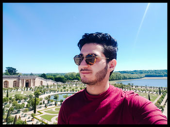 Portrait of young man wearing sunglasses against sky