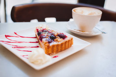 High angle view of pastry with cappuccino served on table