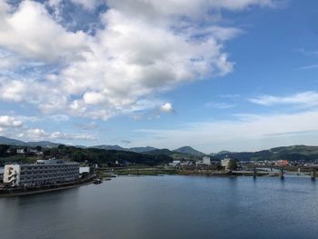 Scenic view of river by town against sky