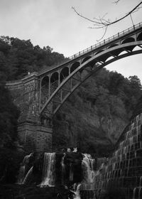 Low angle view of bridge over river against sky