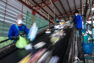Blurred motion of people working in factory