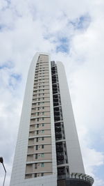 Low angle view of modern building against cloudy sky