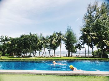 Mother and daughter swimming in pool