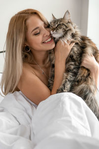 Portrait of smiling young woman with cat