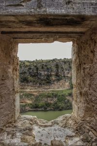 Close-up of old ruin against sky seen through arch