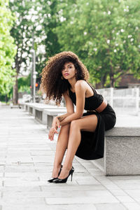 Portrait of young woman sitting in park