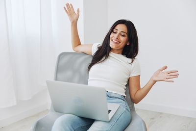 Portrait of young woman using laptop at home