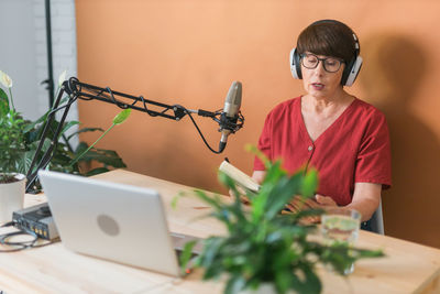 Side view of woman using mobile phone at home