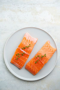 Fresh salmon fillet with herbs on a plate for delicious salmon steak.