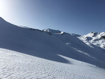 Scenic view of snowcapped mountains against clear blue sky