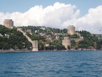 Buildings by sea against sky in city