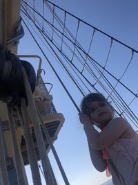 Low angle view portrait of cute girl against sky