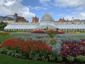 View of flowering plants in front of historical building