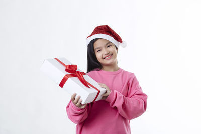 Portrait of a smiling young woman against white background